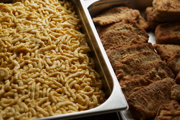 a pile of homemade swabian spaetzle pasta noodles and homemade breaded pork schnitzel in a...
