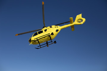 Helicóptero Amarillo sobre cielo azul preparado para iniciar vuelo de ala rotatoria 