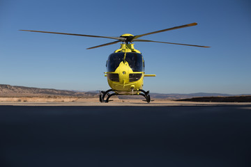 Helicóptero Amarillo sobre cielo azul preparado para iniciar vuelo de ala rotatoria 