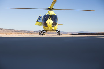 Helicóptero Amarillo sobre cielo azul preparado para iniciar vuelo de ala rotatoria 