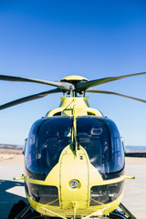Helicóptero Amarillo sobre cielo azul preparado para iniciar vuelo de ala rotatoria 