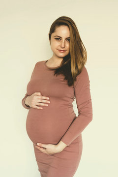Portrait of young pregnant woman isolated. Toned image.