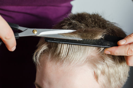 Woman Cuts Hair Of Boy At Home. Homemade Haircut