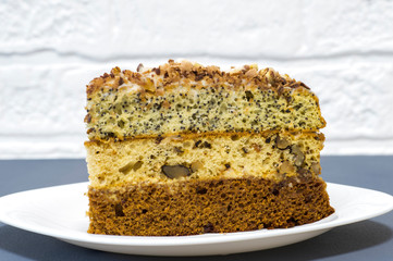 Chocolate cake with a separate piece on a white plate on a gray background