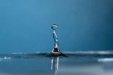 Water Drop falling making droplet splash and waves clean and fresh symbol.