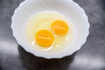 Fresh Egg With Bowl of Egg White on grey Table, Food Style.