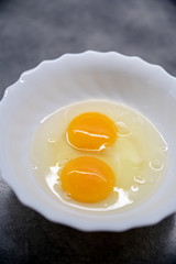 Fresh Egg With Bowl of Egg White on grey Table, Food Style.