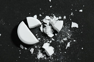 One broken white pill on black background macro photo - concept of medicine and medication...
