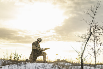 Modern war soldier army Man in the winter desert put gun on the ground and knelt down. full...