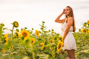 Fototapeta premium Lifestyle in the city of Pamplona, a young blonde enjoying a field of sunflowers