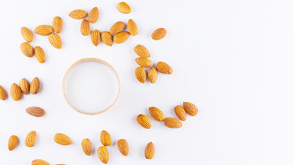 Almond milk with almond on white background. Homemade organic almond milk in a paper cup for healthy breakfast. Vegan milk from almonds nuts in kraft paper cup. Alternative milk. Zero waste