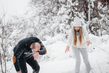 Couple playing with snow in the forest