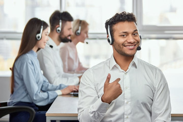 Portrait of black indian man pointing at himself. Call center operator pointing at himself. It's me.