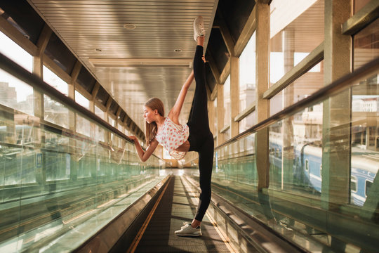 ballerina stands in a tunnel lifting her leg high