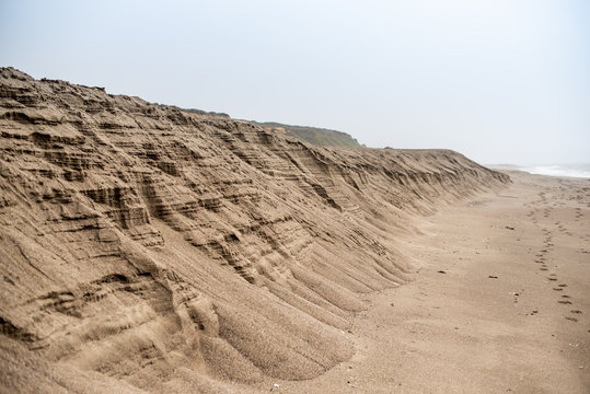 Tall Sand dune receding into distance along shore of beach