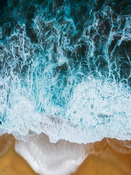 Aerial drone view of beach and ocean waves crashing no people