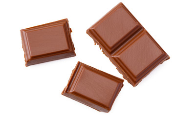 Milk chocolate pieces isolated on white background. top view