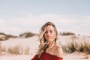 twenty year old woman in the desert with hair blowing in her face