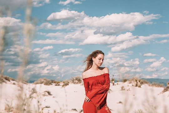 twenty year old woman in a red dress in the desert