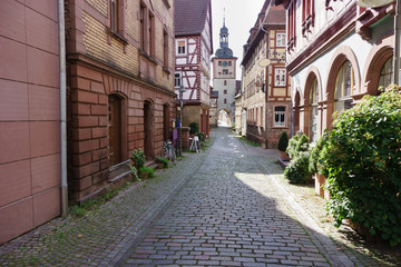 Fototapeta na wymiar Historic medieval old town with half-timbered houses and cobblestone pavement and city gate with archway