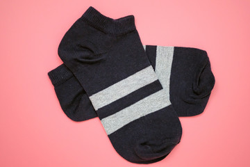 Dark blue sports socks top view. Black short pair socks on a pink background. Women's cotton socks for sports.