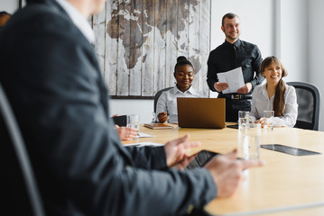 Portrait of a modern business team working at new project during meeting and looking at laptop. Multiracial business people working together.