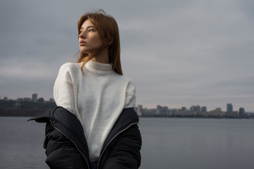 Fototapeta premium Portrait of woman in winter wear against city background