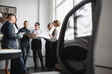 High angle view of successful young business people using gadgets, sharing ideas and smiling while working in office