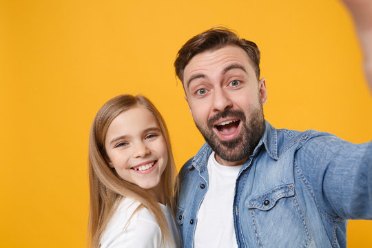 Close up of cheerful bearded man with cute child baby girl. Father little kid daughter isolated on yellow background. Love family day parenthood childhood concept. Doing selfie shot on mobile phone.