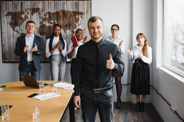 Successful proud business man team leader boss raise hands celebrate corporate victory, goal achievement, professional triumph, success in teamwork concept with happy team in office, rear back view