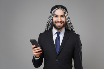 Smiling arabian muslim businessman in keffiyeh kafiya ring igal agal classic black suit isolated on...