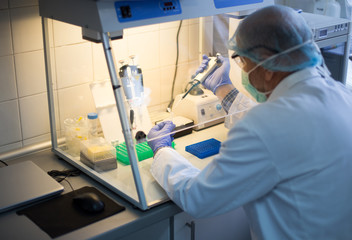 Biologist working in glove box in laboratory