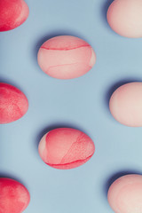 Pattern of pink eggs on a blue background. Geometric Easter Concept