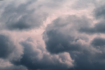 Grey stormy clouds in sky on sunset.