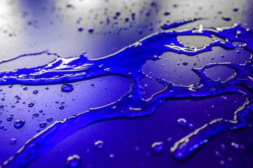 Water droplets on waterproof surface of the car vinyl film are blue purple. Texture