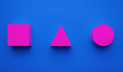 Magenta colored circle, triangle and square made of paper on blue background. Creative futuristic...