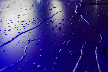 Water droplets on waterproof surface of the car vinyl film are blue purple. Texture