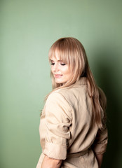 portrait of a blonde in a jacket on green background