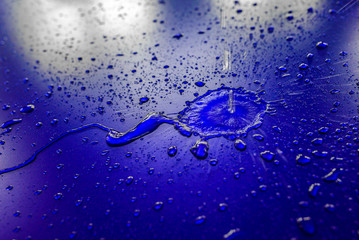 Water droplets on waterproof surface of the car vinyl film are blue purple. Texture