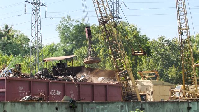 4k video of big industrial electric magnet lifting iron scrap on the scrapyard. Concept of metal recycling