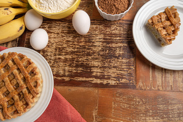 Homemade banana pie with cinnamon and a golden crust, on a wooden background