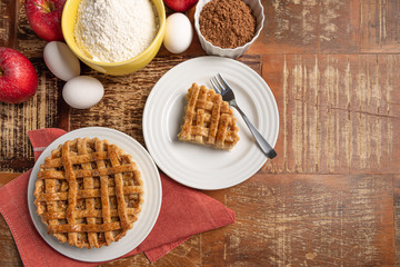 Homemade apple pie with cinnamon and a golden crust, on a wooden background