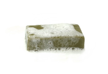 Hand made Olive Soap bar with foam isolated on white background. Wet bar of soap.
