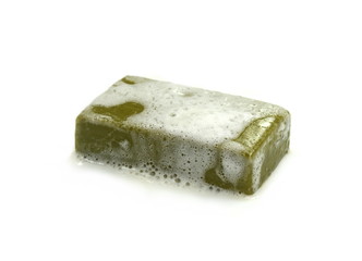 Hand made Olive Soap bar with foam isolated on white background. Wet bar of soap.
