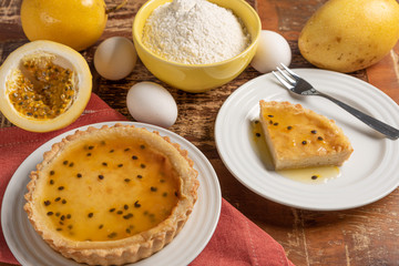 Homemade passion fruit pie with and a golden crust, on wooden background