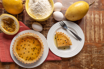 Homemade passion fruit pie with and a golden crust, on wooden background