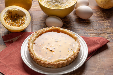 Homemade passion fruit pie with and a golden crust, on wooden background
