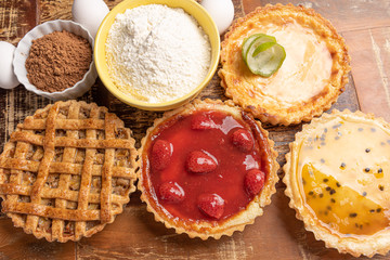 Assortment of homemade  pies with and a golden crust, on wooden background