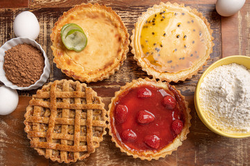 Assortment of homemade  pies with and a golden crust, on wooden background