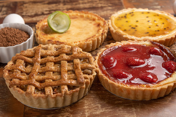 Assortment of homemade  pies with and a golden crust, on wooden background
